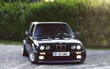 Черный BMW 3 series прячется за кустами